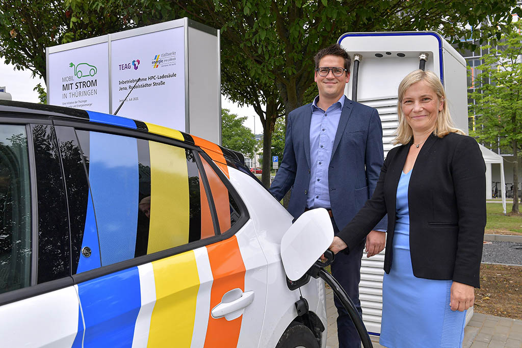 Denis Schuldig, Projektleiter Elektromobilität der TEAG, und Claudia Budich, Geschäftsführerin Stadtwerke Energie Jena-Pößneck, beim ersten offiziellen Ladevorgang an den neuen Schnellladern.