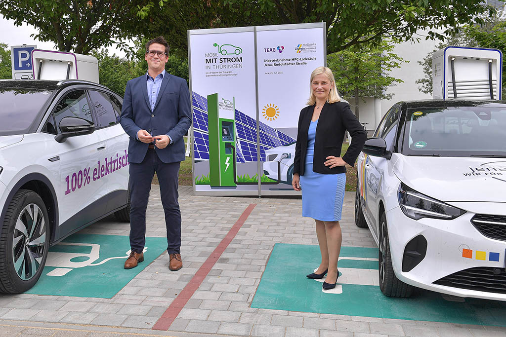 Denis Schuldig, Projektleiter Elektromobilität der TEAG, und Claudia Budich, Geschäftsführerin Stadtwerke Energie Jena-Pößneck, vor den zwei neuen Schnellladern in Jena-Winzerla.