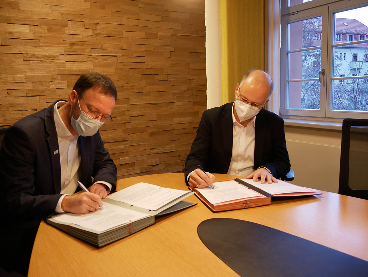 Dr. Thomas Nitzsche und Tobias Wolfrum unterzeichnen den Kooperationsvertrag zur Unterbringung von Geflüchteten. Foto: Stadt Jena