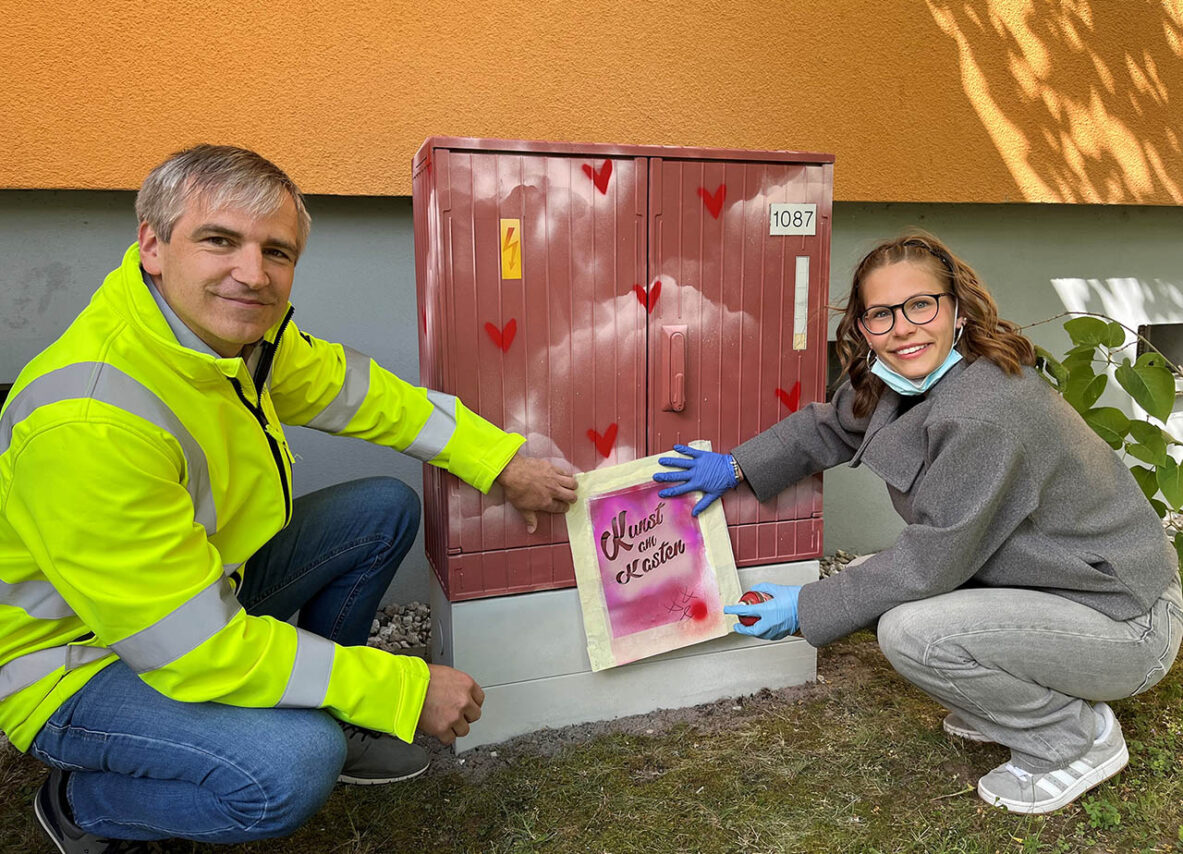 Kunst am Kasten Tobias und Leni – Tobias Nachtwey, Bereichsleiter Strom/Wärme bei den Stadtwerken Jena Netze, und Leni aus der Klasse 10 der Kulturanum-Schule sprühen gemeinsam das Projekt-Logo „Kunst am Kasten“ an. Foto: Stadtwerke Jena