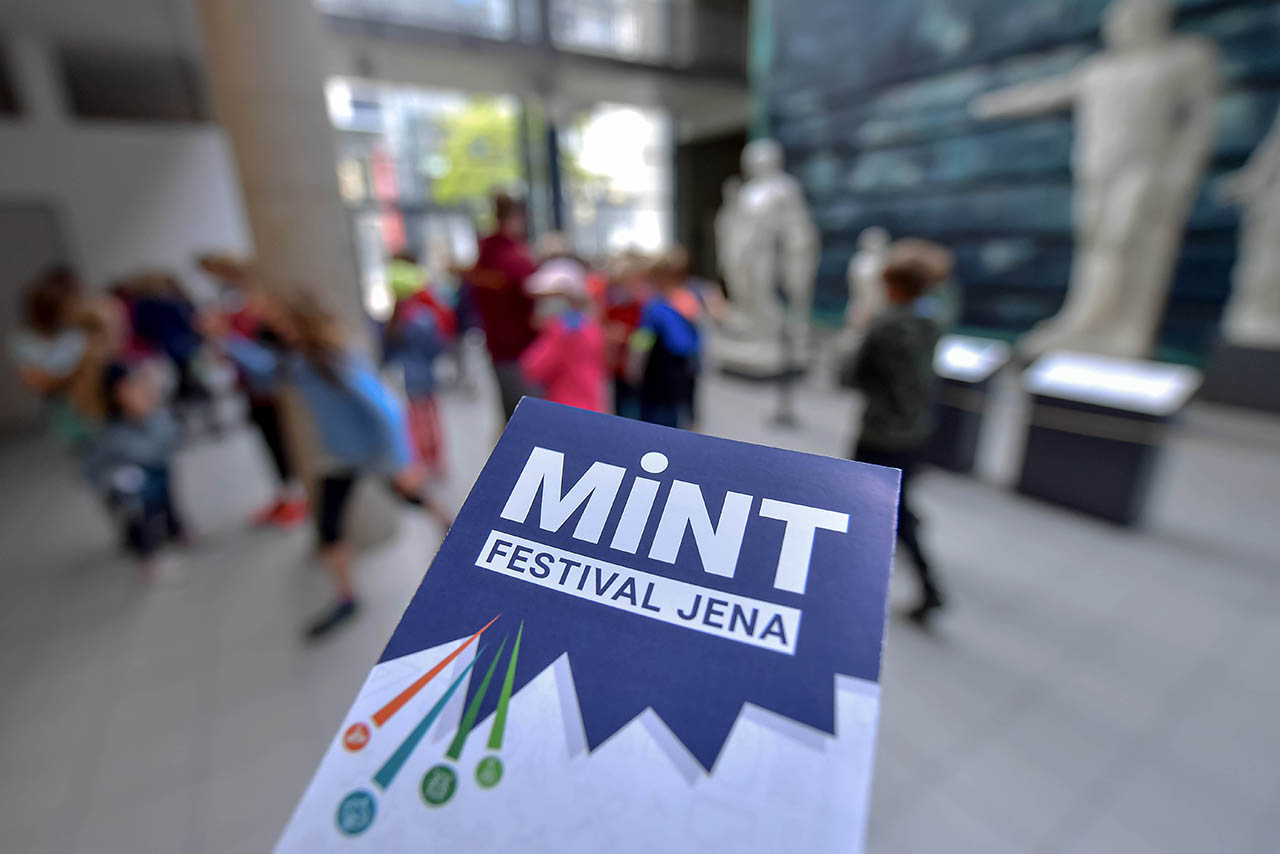 Symbolbild mit dem Programmflyer des MINT-Festivals Jena (Foto: Jürgen Scheere/Universität Jena)