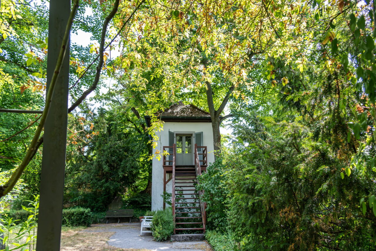 Erkunde den historischen Garten mit Steintisch, Gartenzinne und Küchenhäuschen – ein Ort zum Verweilen und Nachdenken.