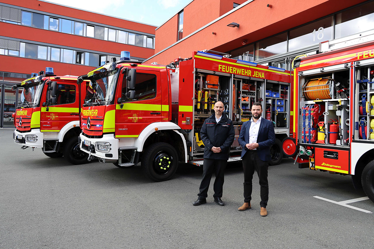 Drei neue Einsatzfahrzeuge stärken die Feuerwehr Jena: Zwei HLF und ein Rüstwagen sorgen für mehr Sicherheit und schnellere Hilfeleistung. Bürgermeister Benjamin Koppe (rechts) und Fachdienstleiter Feuerwehr Nick Ludwig präsentieren die neuen Einsatzfahrzeuge der Berufsfeuerwehr Jena. Foto: Stadt Jena