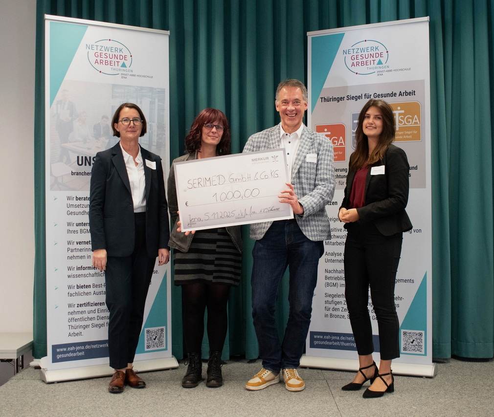 Gesunde Arbeit 2025: EAH Jena zeigt Wege. Der Förderpreises der MERKUR PRIVATBANK KGaA ging in diesem Jahr an die SERIMED GmbH & Co. KG; v.l.n.r.: Nicole Meier (MERKUR PRIVATBANK KGaA), Evelyn Frost-Ullmann (SERIMED GmbH & Co. KG), Michael Schilling (SERIMED GmbH & Co. KG), Rebecca Schwarz (MERKUR PRIVATBANK KGaA); Foto: Lena Viertel // EAH Jena Gesunde Arbeit 2025: EAH Jena zeigt Wege. Der Förderpreises der MERKUR PRIVATBANK KGaA ging in diesem Jahr an die SERIMED GmbH & Co. KG; v.l.n.r.: Nicole Meier (MERKUR PRIVATBANK KGaA), Evelyn Frost-Ullmann (SERIMED GmbH & Co. KG), Michael Schilling (SERIMED GmbH & Co. KG), Rebecca Schwarz (MERKUR PRIVATBANK KGaA); Foto: Lena Viertel // EAH Jena