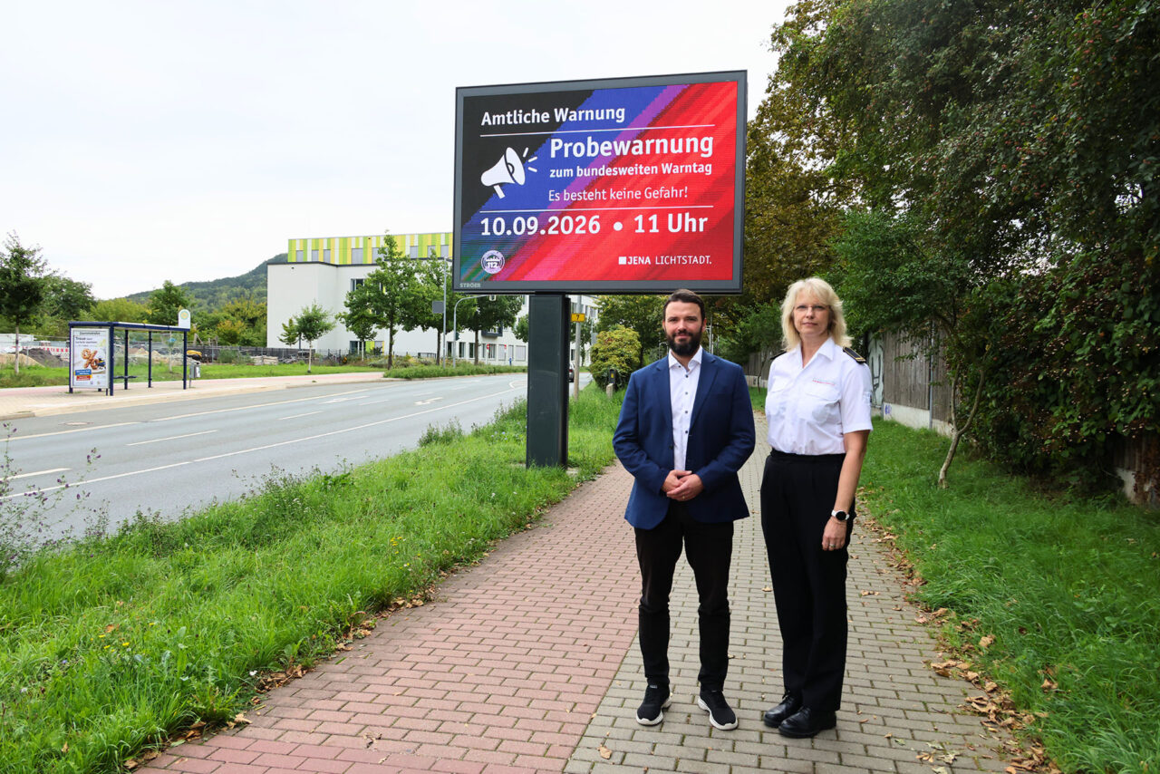Bundesweiter Warntag 2026. Warnung auf mehreren Wegen: Bürgermeister Benjamin Koppe und die stellvertretende Fachdienstleiterin Feuerwehr, Anja Le Maire, vor einer digitalen Anzeigetafel zum bundesweiten Warntag. Am 10. September testet Jena das Zusammenspiel seiner Warnsysteme. Foto: Stadt Jena Bundesweiter Warntag 2026. Warnung auf mehreren Wegen: Bürgermeister Benjamin Koppe und die stellvertretende Fachdienstleiterin Feuerwehr, Anja Le Maire, vor einer digitalen Anzeigetafel zum bundesweiten Warntag. Am 10. September testet Jena das Zusammenspiel seiner Warnsysteme.Foto: Stadt Jena