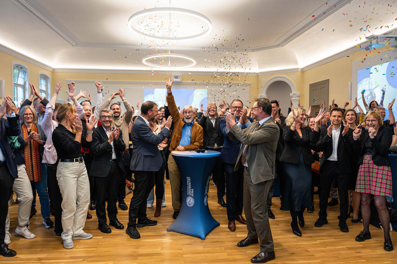 Die Friedrich-Schiller-Universität Jena erhält den Status als Exzellenzuniversität. Grundlage sind zwei Exzellenzcluster und das Konzept „Light. Life. Liberty.“ Jubel an der Friedrich-Schiller-Universität Jena nach der Bekanntgabe der Entscheidung der Exzellenzkommission am 02.10.2026 in den Rosensälen der Friedrich-Schiller-Universität Jena in Jena. Die Universität Jena erhält den Status einer Exzellenzuniversität. Nachdem sie sich mit ihren beiden Exzellenzclustern „Balance of the Microverse“ und „Imaginamics. Practices and Dynamics of Social Imagining“ für die Förderlinie Exzellenzuniversitäten qualifiziert hatte, reichte sie 2025 ihren Antrag auf Förderung als Exzellenzuniversität unter dem Titel „Light. Life. Liberty. – Connecting People and Ideas“ ein. Foto: Nicole Nerger/Universität Jena